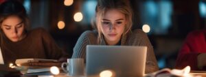 Girl in cozy sweater studying late at night on a laptop surrounded by warm lights