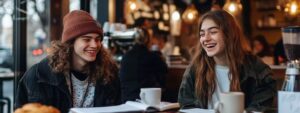 Two students enjoying coffee and studying together at a café.