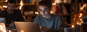 A student concentrating on her laptop in a library decorated with string lights.